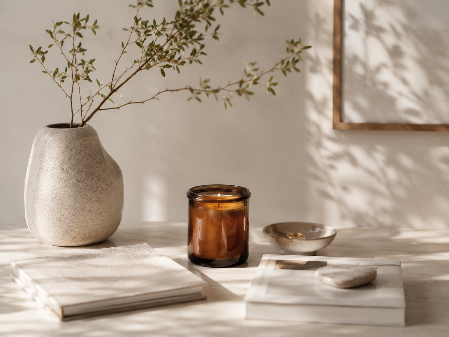 Candle, vase, and books in soft morning light